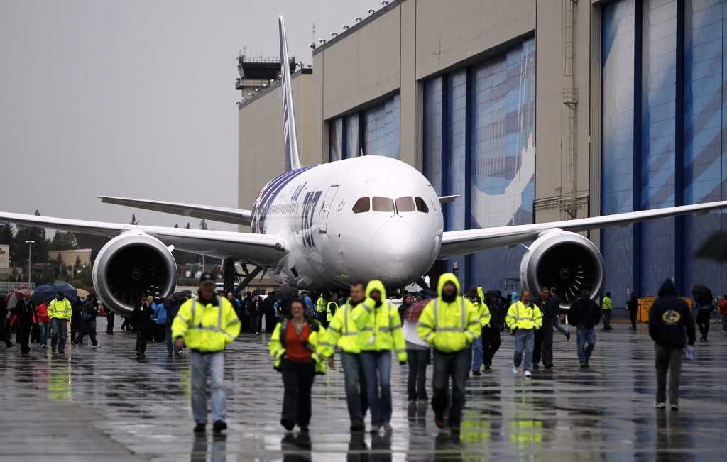 Boeing employees walk around 787 Dreamliner scheduled for delivery to ANA parked next to Boeing Everett Factory at Paine Field in Everett