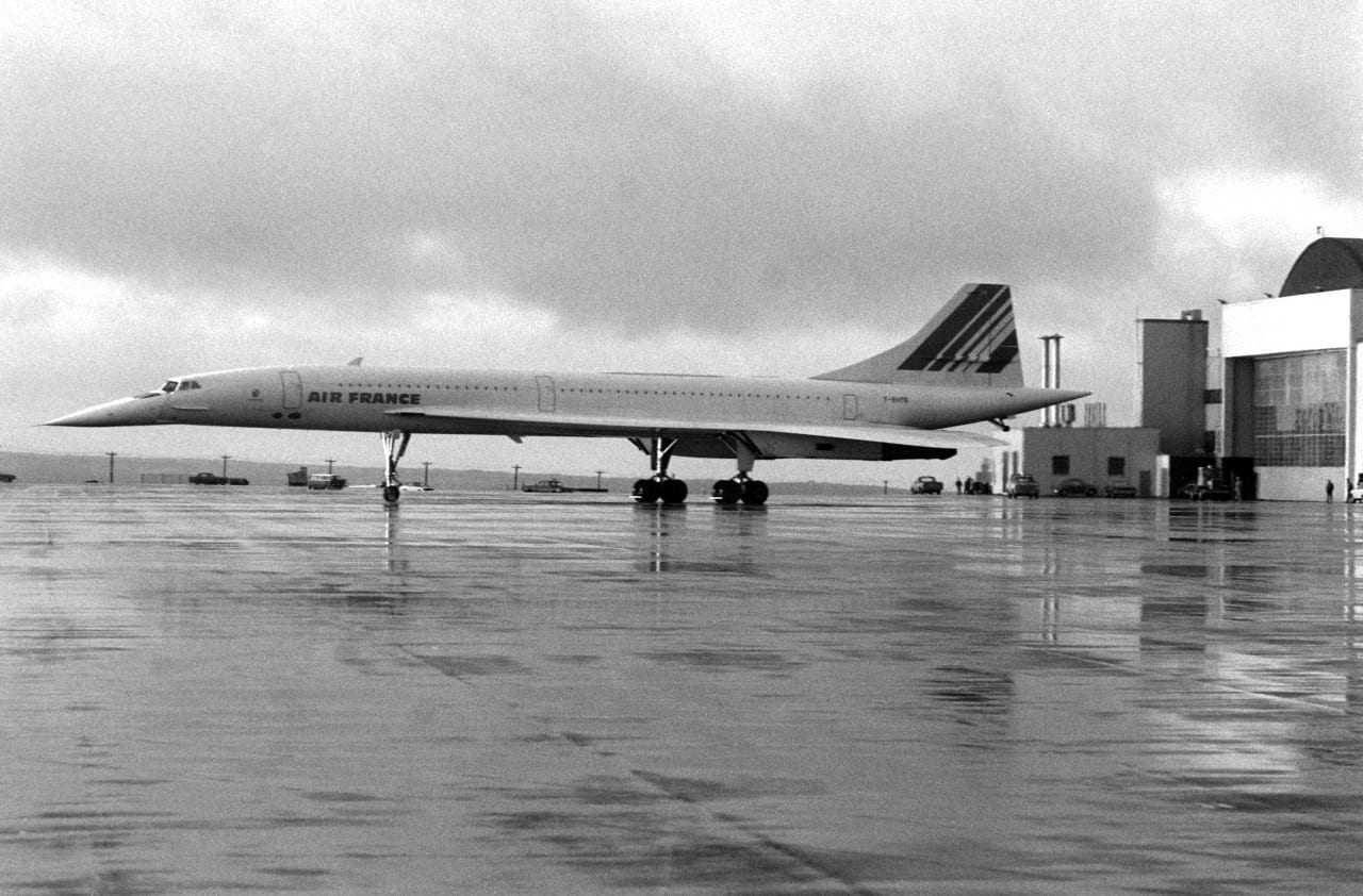 A left side view of an Air France Concorde supersonic passenger aircraft parked on the flight line during a stopover at the air station.