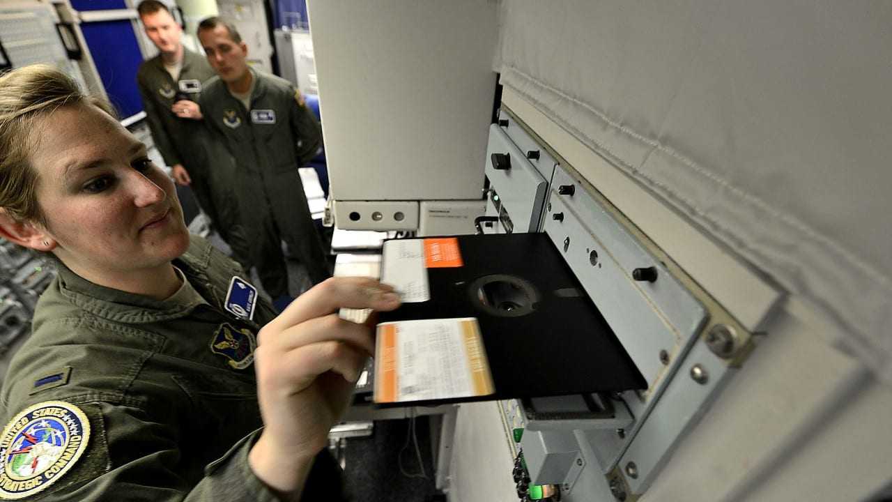 Missile combat crew member 1st Lt. Katie Grimley slides a large floppy disk into a 60's era communication module inside the launch control center of a missile alert facility at Malmstrom Air Force Base. The U.S. govt. is embarking on a $400 billion modernization to its nuclear weapons arsenal.